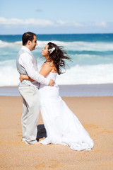 Fototapeta na wymiar happy groom and bride hugging on beach