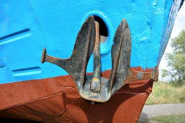 Судно рыбацкое на берегу водоема. Якорь крупным планом