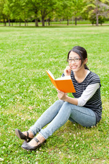Fototapeta premium asian woman reading a book in the park