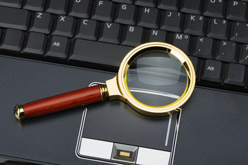 Magnifying glass and a laptop