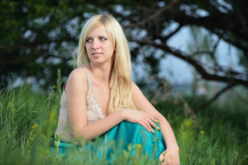 Portrait of a pretty woman sitting in the grass