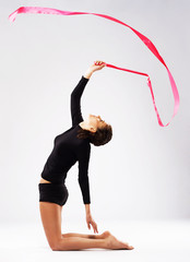 Young gymnast woman training with a ribbon