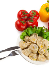 Tasty pelmeni with tomato and salad