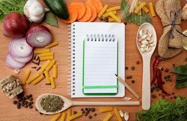 notebook for recipes and spices on wooden table