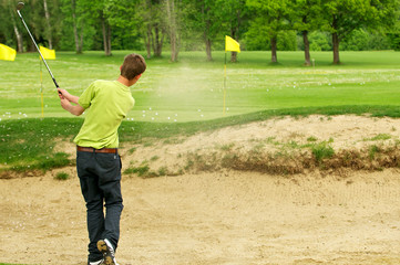 Junger Golfspieler beim Abschlag im Bunker