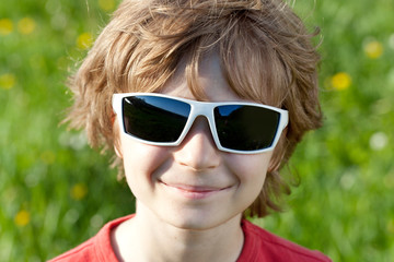 Blonde naughty little boy wearing sunglasses