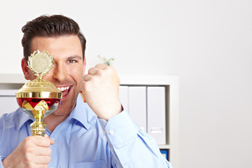 Manager mit Pokal und geballter Faust