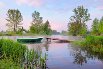 Rural landscape with boat and footbridge on the Narew river.