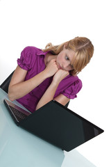 Office worker looking sadly at her laptop