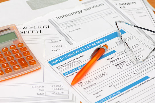 Surgery bills with health insurance claim calculator and pen