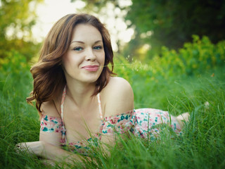The young woman lies in a green grass