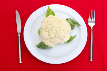 Fresh cauliflower on plate, knife and fork