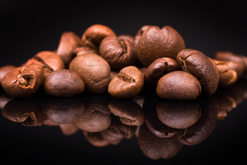 heap of coffee beans on black background