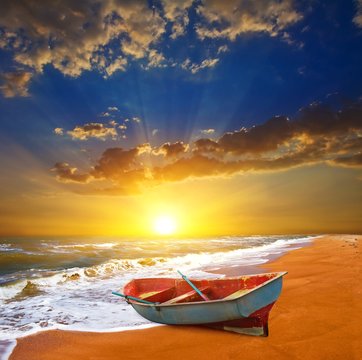 small boat on a sea coast at the sunset