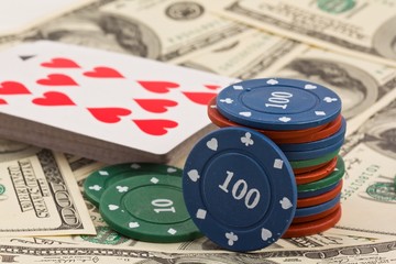 playing chips and cards on a dollars banknotes