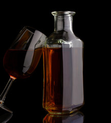 Cognac bottle and glass isolated on black