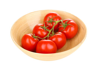 Fresh tomatoes in wooden bowl isolated on white