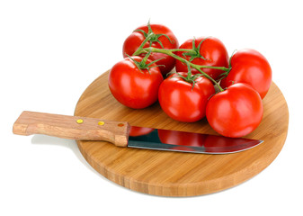 Fresh tomatoes and knife on wooden board isolated on white