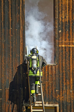 firefighters with oxygen cylinder to peg up the ladder to exting