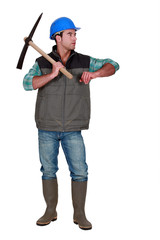 Construction worker with a pickaxe leaning on empty copyspace