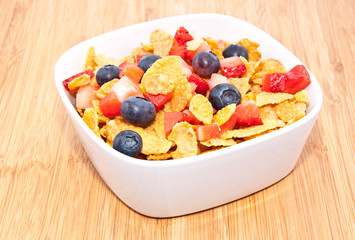 Cornflakes with fruits on wood