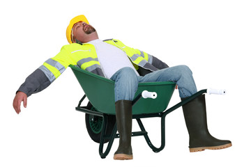 Tradesman asleep in a wheelbarrow - obrazy, fototapety, plakaty