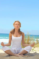 Fototapeta na wymiar Woman meditating on a beach