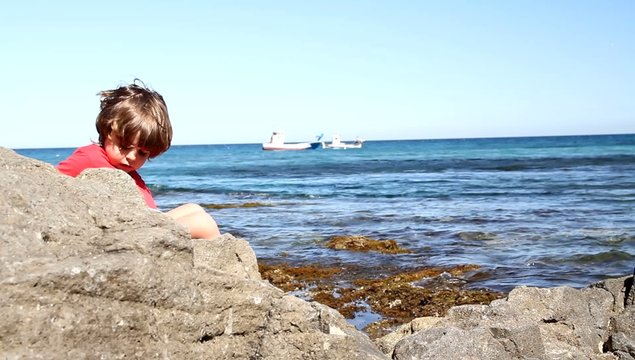 ni&ntilde;o en rocas de playa