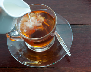 Mug of tea, coffee with milk pouring in