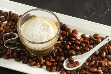 delicious cappuccino in a tray stuffed with coffee beans