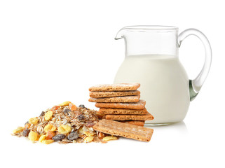 Glass jug with milk, cracker and muesli