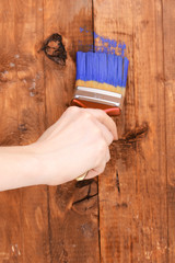 Painting wooden fence with yellow paint