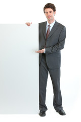 Modern businessman pointing on blank billboard