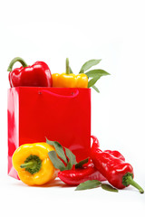 Healthy food. Fresh vegetables.Peppers in a red gift bag on a wh