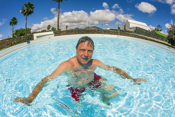 attractive man enjoys swimming in the pool