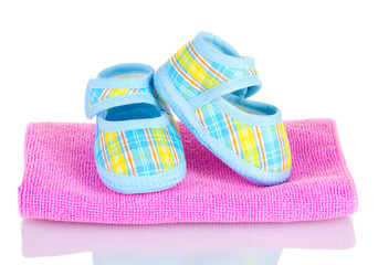 Blue baby booties on pink towel isolated on white