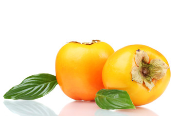 Two appetizing persimmons with green leaves isolated on white