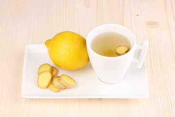 Healthy ginger tea with lemon on wooden background