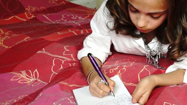 junior &eacute;crivant  sur son lit