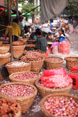 Vegetable market with bacskets of onions in Yangon, Myanmar