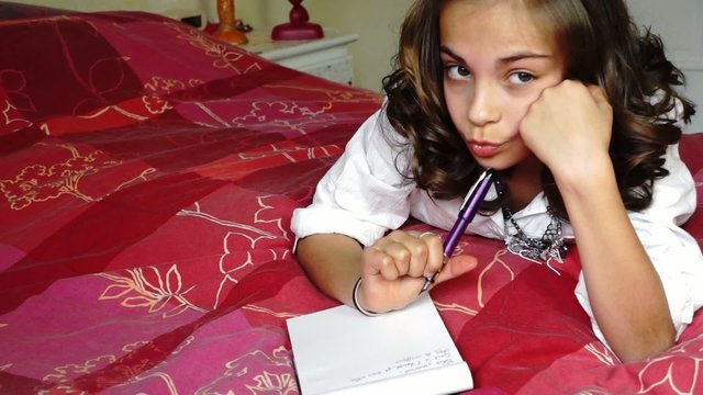 junior &eacute;crivant  sur son lit