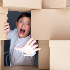Portrait of young woman surrounded by lots of boxes