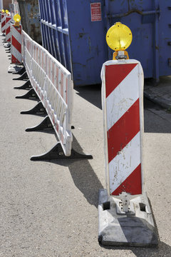 Red and white striped road warning posts with yellow beacons