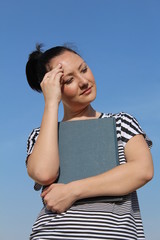 Brunette young woman holding book and thinking