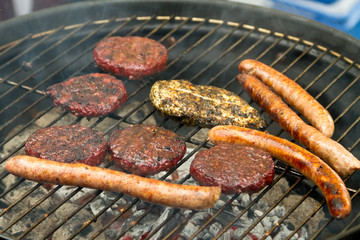 Burgers and sausages on barbecue