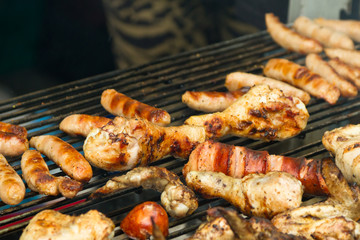 Chicken meat and sausages on barbecue