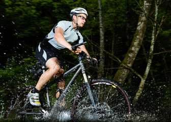 Mountainbiker durchquert Bachbett