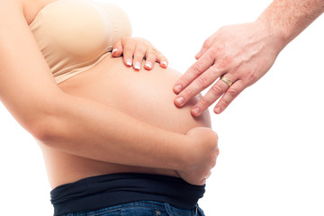 Male hand touching pregnant woman belly