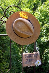 Strohhut, rostiger Dekozaun, Schild "Gartenzeit"