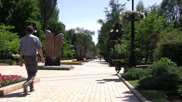 Мужчина прогуливается по городской аллее